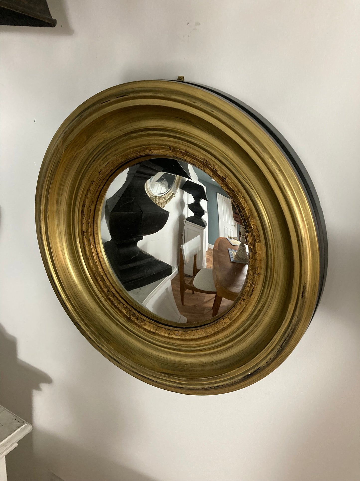 A Modern Regency Style Gold Circular Convex Mirror with ebonsied Rim