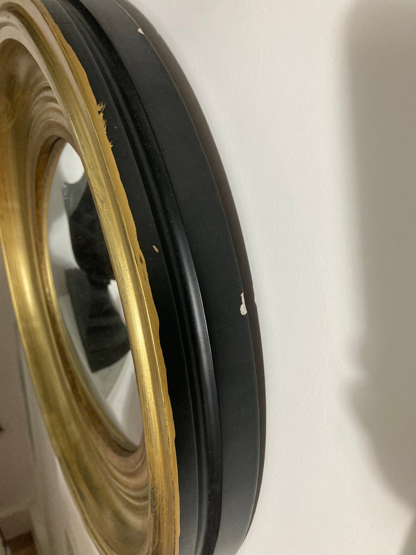 A Modern Regency Style Gold Circular Convex Mirror with ebonsied Rim