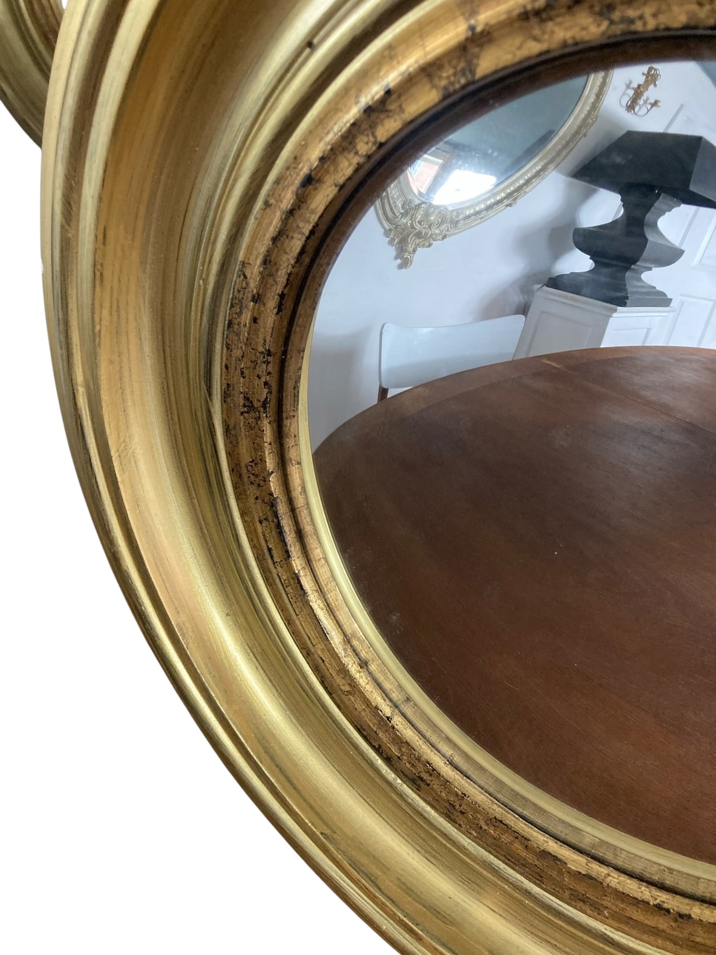 A Modern Regency Style Gold Circular Convex Mirror with ebonsied Rim