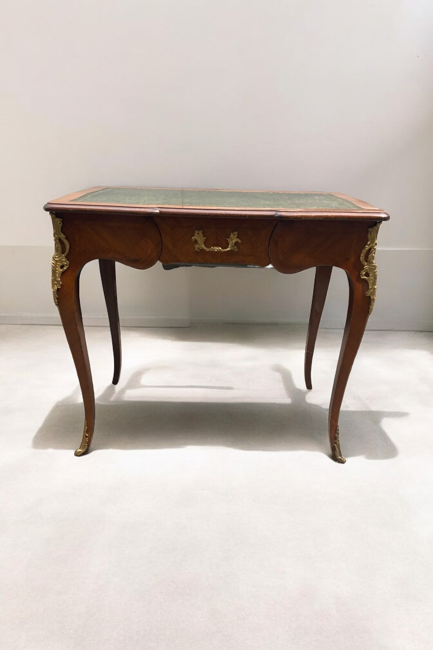 French Louis XV Style writing Desk green leather covered top ornate brass moldings single drawer.