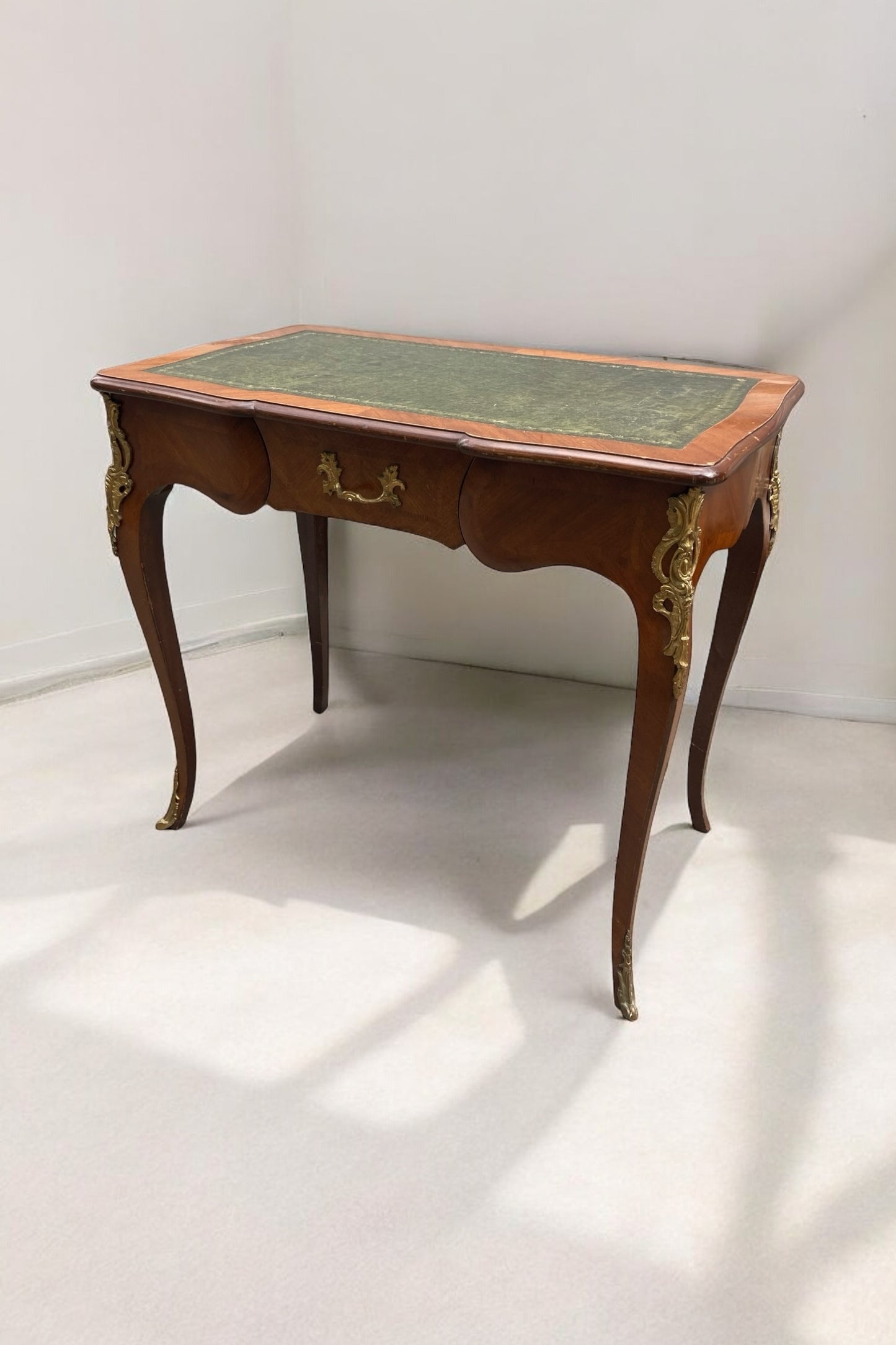 French Louis XV Style writing Desk green leather covered top ornate brass moldings single drawer.