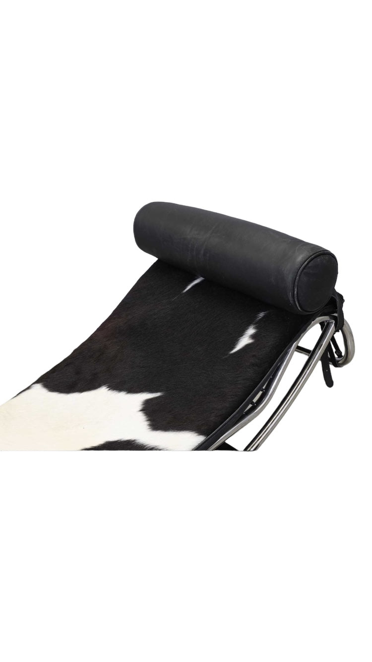 An 'LC4'  Le Corbusier Style chaise longue,upholstered in pony hide and with a black leather neck roll cushion to the chromium-plated tubular frame,